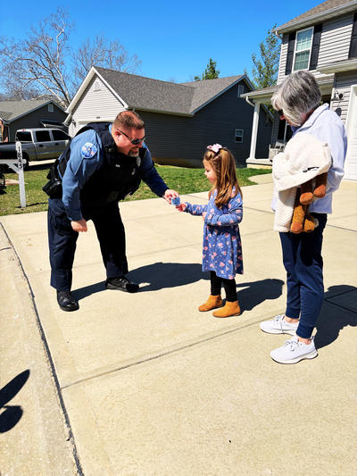 male officer giving female child sticker