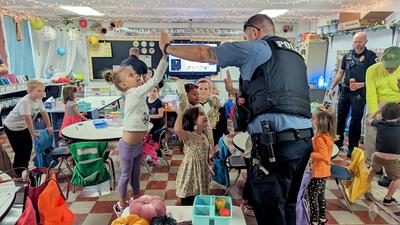 male officer high-fiving children